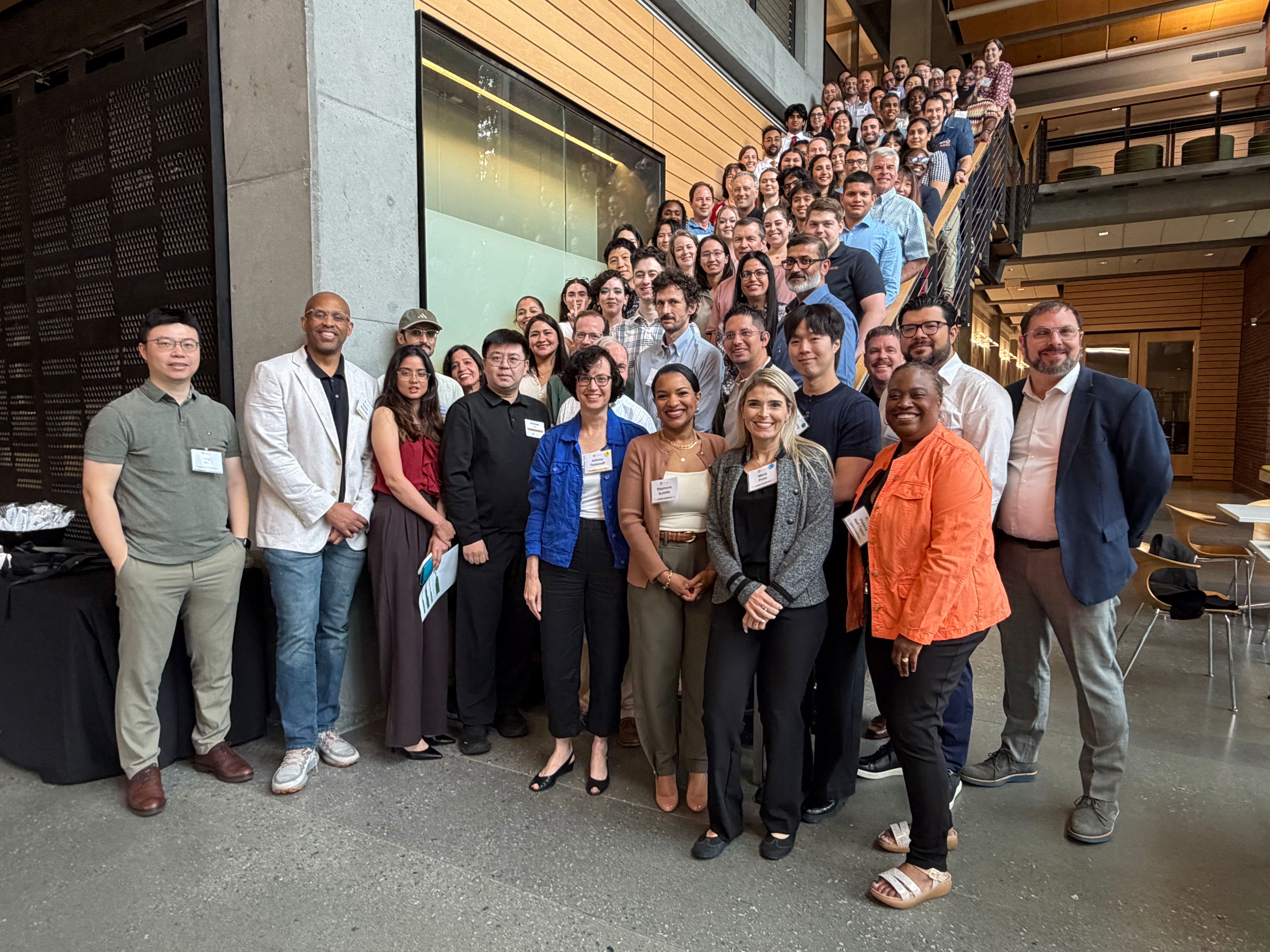CMaT researchers, staff, trainees, and industry partners pose for a photo on a staircase.